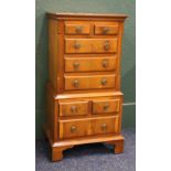 Yew wood multi drawer bedside chest raised on bracket supports, 77 cm high x 38 cm wide.