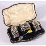 Cased silver three piece condiment set with non matching silver spoon, each piece with swag