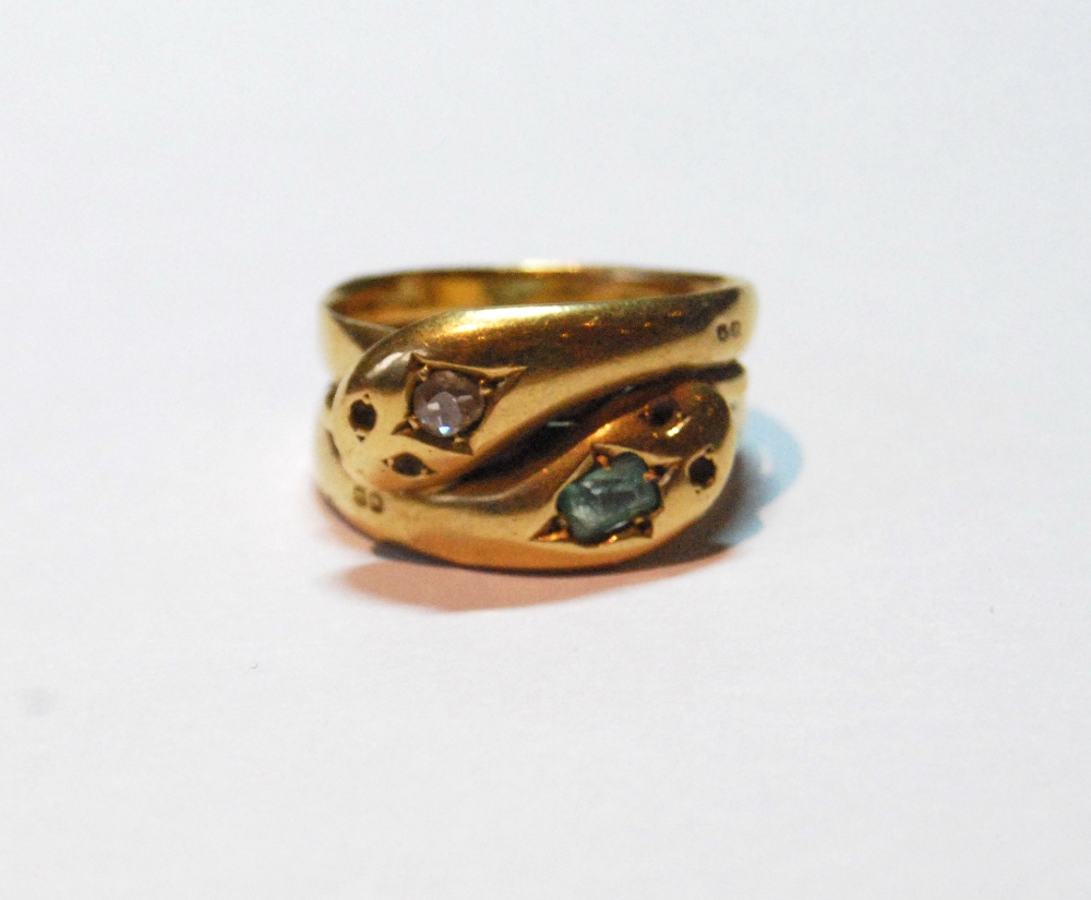 Gold ring modelled as two entwined serpents, the heads with a diamond and an emerald, Birmingham