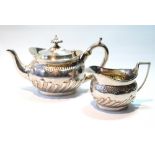 Silver oval teapot and milk jug with waved gadrooning by C.S. Harris,1895/1911, 7oz.  (2)