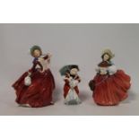 Three Royal Doulton figures: "Autumn Breezes", HN1934, 20cm high; "The Skater", HN2117, 18.5cm