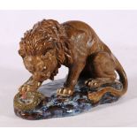 A 20th Century Chinese finely modelled lion and snake group on a naturalistic base, the lion
