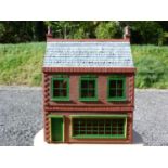 Dolls house. Red brick effect, shop window front, contains various contents 83cm high 63cm long