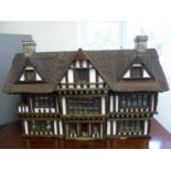 Dolls house. A Robert Stubbs mock Tudor thatched dolls house of half-timbered design with central