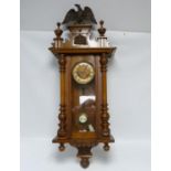 Early 20th century pendulum wall clock in glazed beech case with half turned pilasters, vase finials