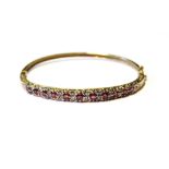 9ct gold hinged bangle with diamonds and rubies, 11.9g.