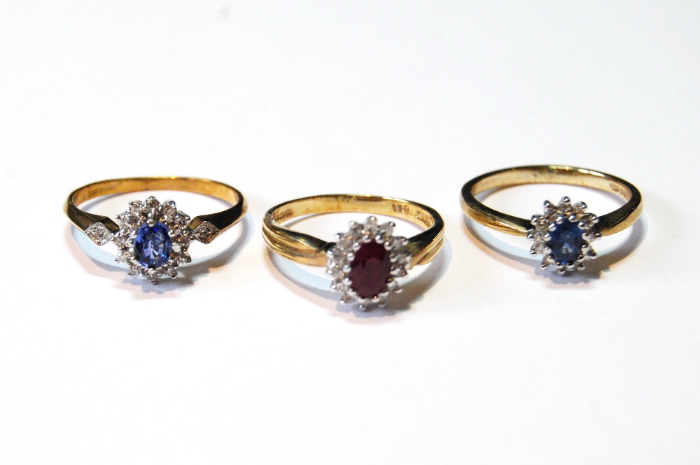 Two diamond and sapphire oval cluster rings and another, with ruby, in 9ct gold, sizes N, O and O½.