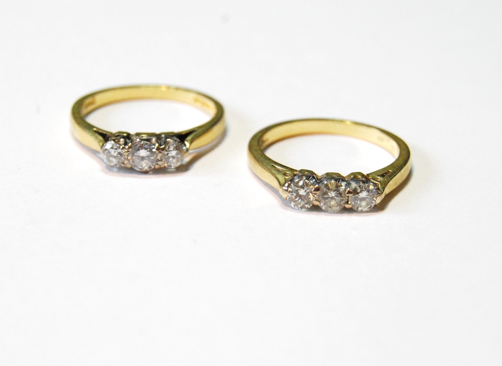 Two diamond three-stone rings in 18ct gold, sizes L and N.
