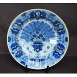 18th century Dutch Delft blue and white shallow dish painted with stylised urn of flowers and