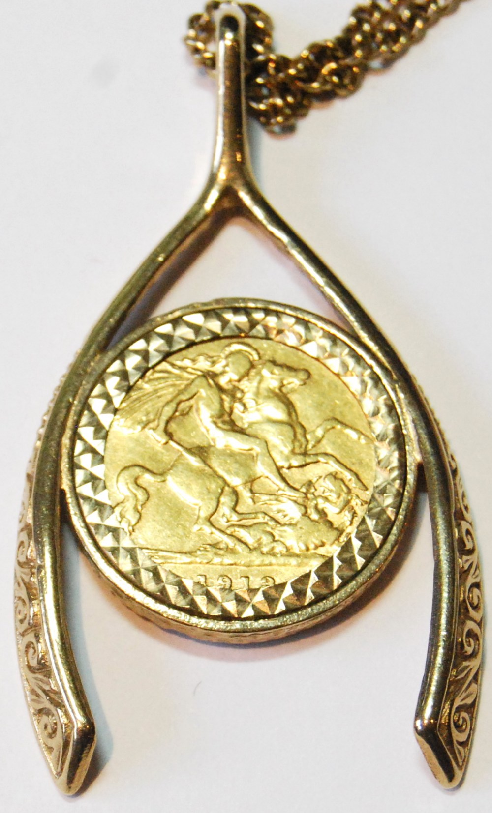 9ct gold pendant modelled as a wishbone enclosing a detachable half sovereign, 1913, 18g. - Image 3 of 3