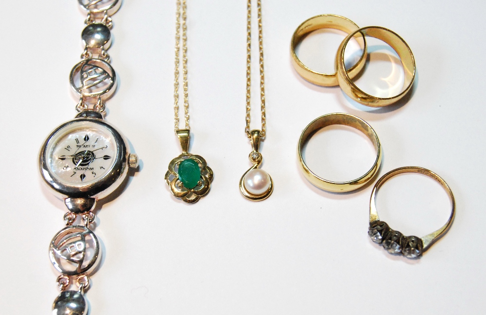 Two gold gem pendants, a silver watch and four metal rings.