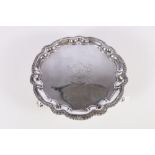 George II silver salver or waiter with feathered pie crust border rim raised on three hoof feet by