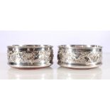 A pair of contemporary silver wine slides decorated with repousse fruiting vines by James Ness and