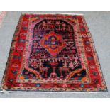 Turkish rug with central lozenge, floral design, black ground and triple border, 170cm x 124cm.