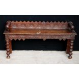 Oak hall bench, the raised carved back panel flanked by ring turned arms, rectangular seat, matching