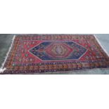 Anatolian rug with central hexagonal medallion, blue diamond field, red ground with geometric floral