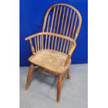 19th century yew wood Windsor chair with comb back, hoop arms, shaped seat raised on baluster turned