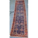 Turkish runner with two rows of floral diamonds, blue ground, red and floral border, 395cm x 95cm.