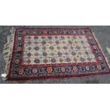 Persian rug with five rows of eleven alternating rosettes over cream ground, floral red and blue