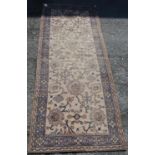 Ushak design rug with foliate design over worn cream ground and faded blue border, 315cm x 115cm.