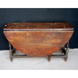 Late 17th or early 18th century oak gateleg table, the oval drop flap top raised on block and turned