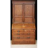 George III oak bureau bookcase, the projected moulded cornice over shell inlaid panelled doors