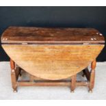 Oak gateleg table, the oval top raised on block and baluster turned legs united by stretcher,