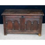 Oak coffer, the rectangular hinged top over arched panels, raised on block feet, 109cm wide, 63cm