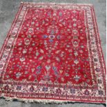 Persian style carpet with all over floral design over red ground and alternate cream floral borders,