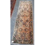 Eastern runner with all over foliate design, cream ground, orange and green border, 317cm x 92cm.