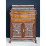 Carved mahogany music cabinet, the stepped top over floral carved frieze, three drawers, floral