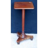 19th century mahogany and rosewood pedestal table, the rounded rectangular top on turned column,