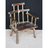 Primitive Welsh style stick back chair, the stepped top rail over serpentine arms and