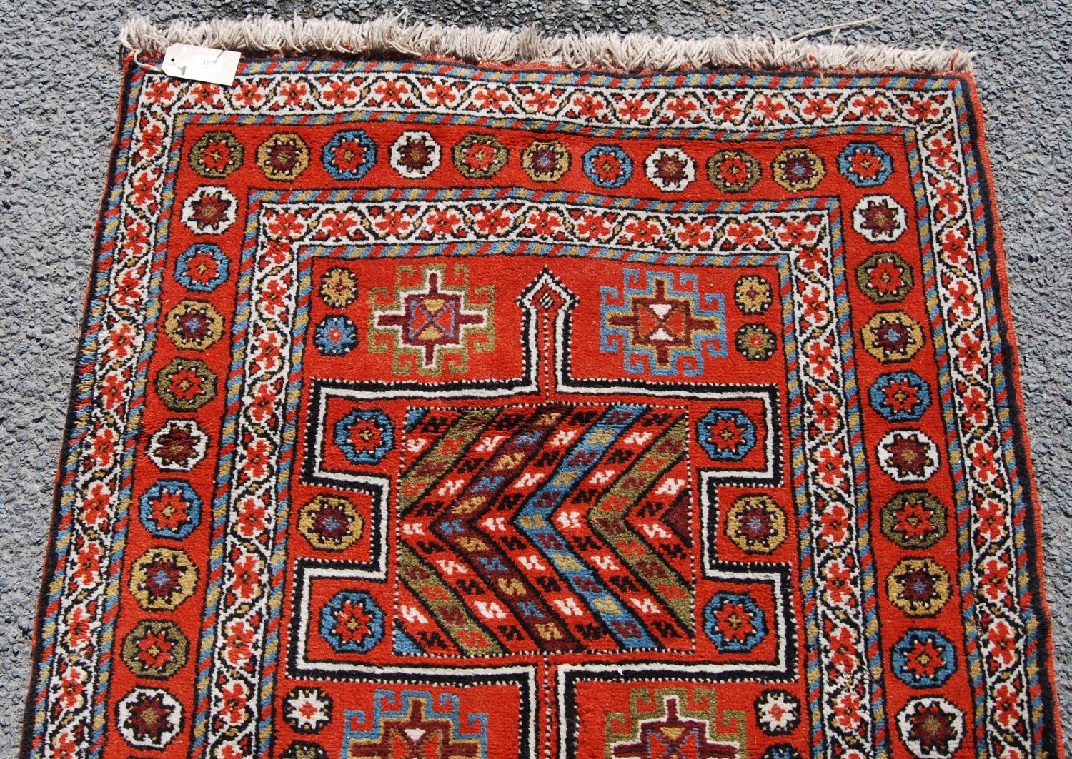 Quchan rug with three H-shaped panels over red ground, rosettes and border, 112cm x 211cm. - Image 4 of 4