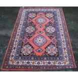 Persian style carpet with two medallions over pink ground, spandrels and triple border, 297cm x