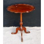 Mahogany piecrust table with tilt top raised on turned supports, acanthus carved cabriole legs