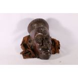 Carved African wood mask with cross scarification to forehead, cowrie shell decoration, material