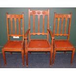 Three Art Nouveau oak dining chairs with carved floral design including carver and two side chairs