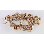 9ct gold curb link charm bracelet with padlock closure and twenty dependant charms including