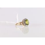 18ct gold dress ring set with faceted oval peridot encircled by sixteen small round diamonds of