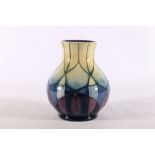 Modern Moorcroft baluster shaped vase with geometric design in purple, blue and green, signed with