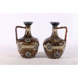Pair of Doulton Lambeth stoneware ewers, impressed to base 1884, initialled MR, 18cm tall