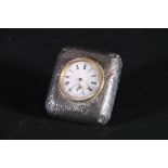 An Edwardian textured silver clad boudoir strut clock having enamel dial with Roman numerals,