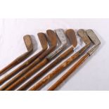 Seven hickory shafted golf clubs including Forgan of St Andrews driving iron, hammer mashie,