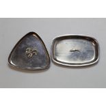 Pair of silver ash trays with embossed floral spray and dolphin by Geoffrey Bellamy for George