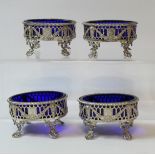 Set of four silver oval salts, pierced with applied embossed swags upon openwork spreading feet,