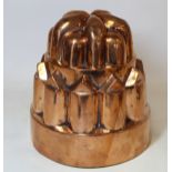 Victorian copper jelly mould of tiered form, unmarked, 16cm diameter and 17cm high.