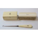 Safety razor in silver mounted ivory case, 1926, and a similar button hook and hair brush.