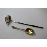 Silver toddy ladle with inset coin and a gilt spoon with figure handle. (2).
