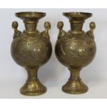 Pair of antique Eastern brass vases, probably Indian, of baluster form with twin figural handles and